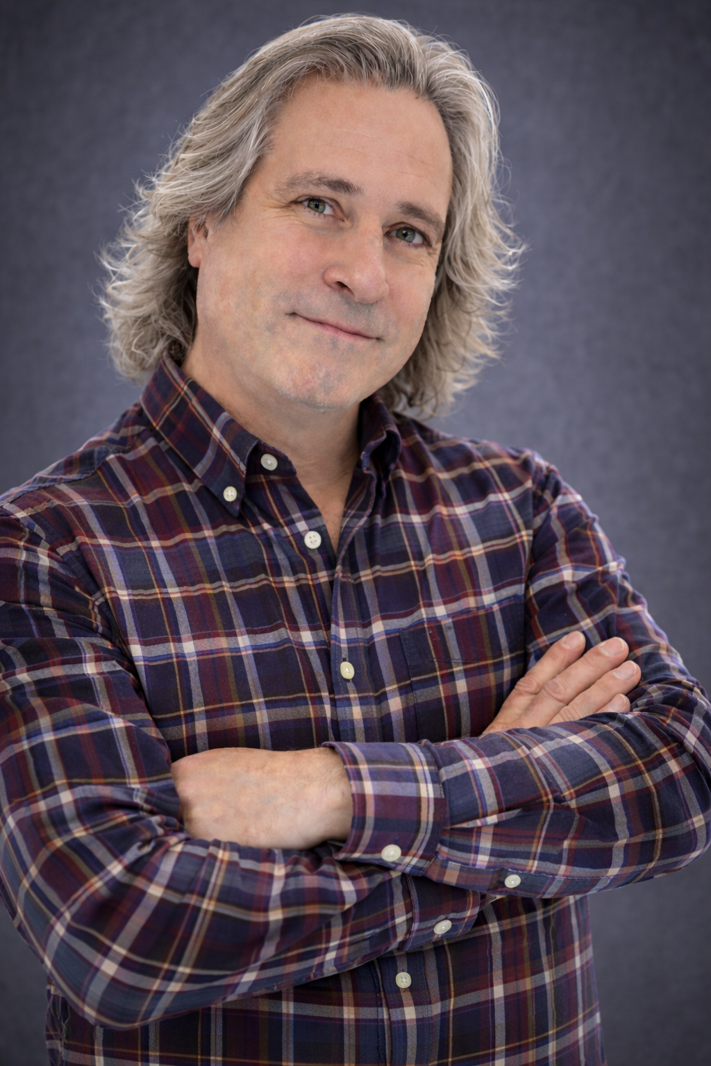 Alan Matthews, Art Director at 38 Sign and Graphics in Knoxville Tennessee, wearing a stylish plaid button-down shirt in a professional studio portrait with arms folded.